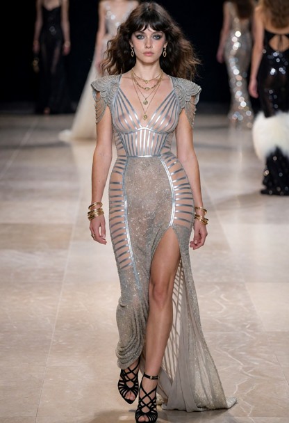one woman seen from her head to her feet. she walking the runway at a paris fashion week fashion show, walking toward…