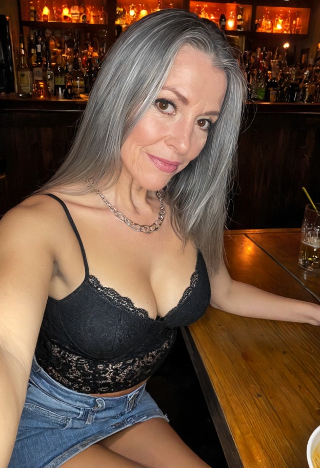 she is sitting at a bar table,dark lace camisole,worn denim skirt,silver necklace,dim bar corner,wooden table,hazy at…