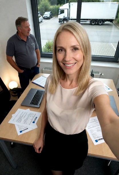 subject arbeitet in einer Spedition im Büro. Das Büro hat zwei Schreibtische. Auf den Tischen jeweils ein Laptop und …