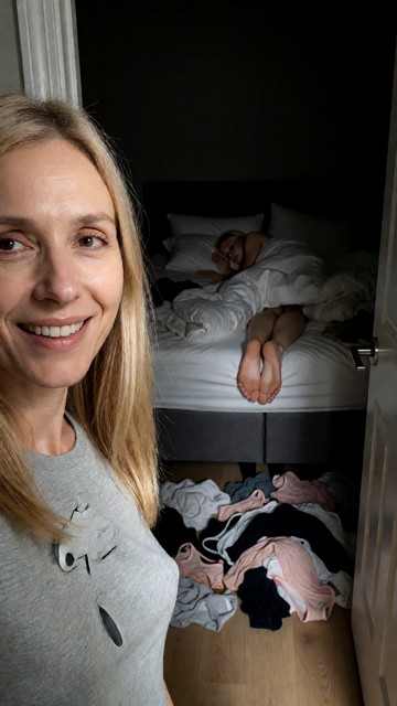 A first-person perspective (POV) taken from a doorway looking into a dark, messy bedroom. In the immediate foreground…